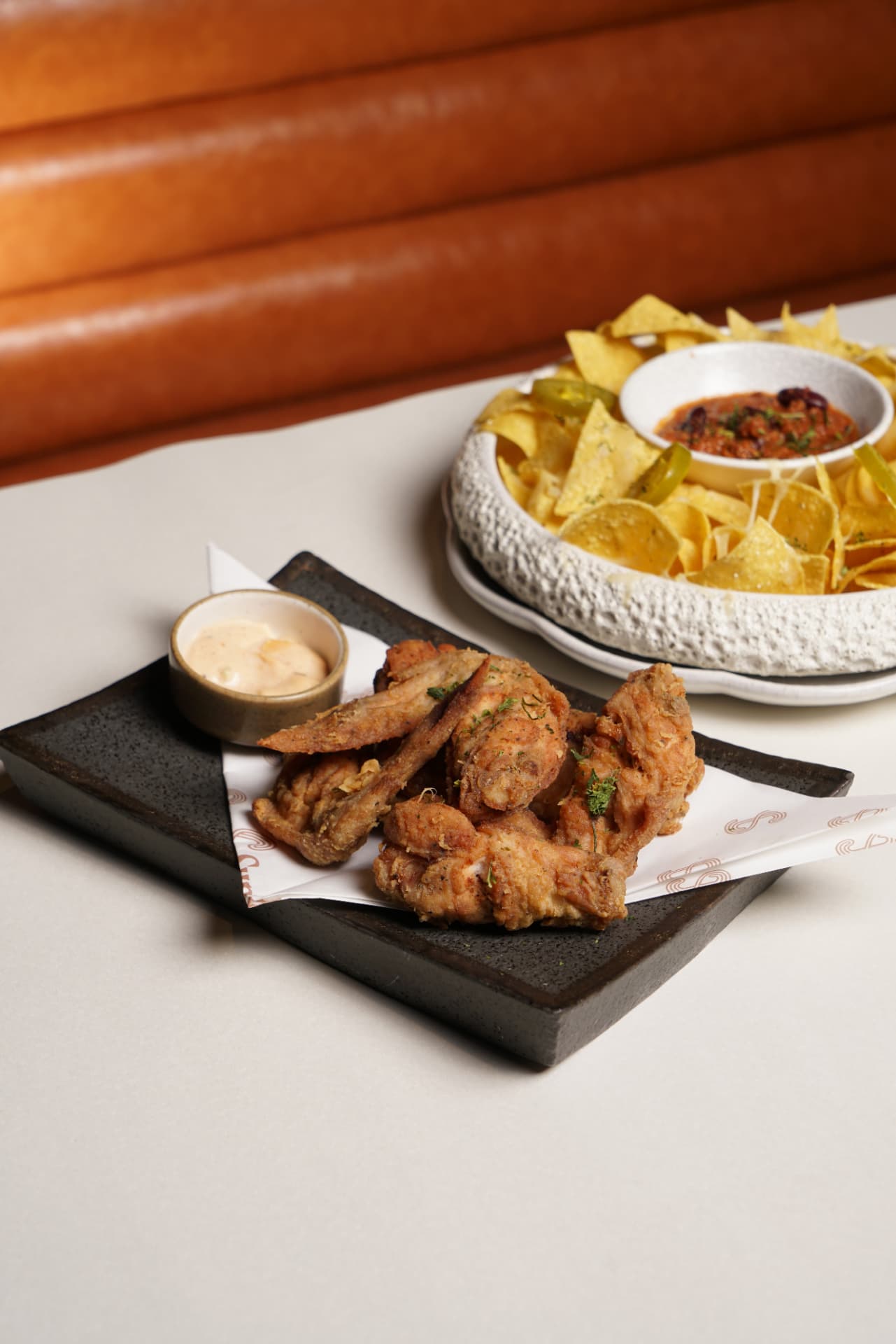 Fried chicken wings and nachos with dips