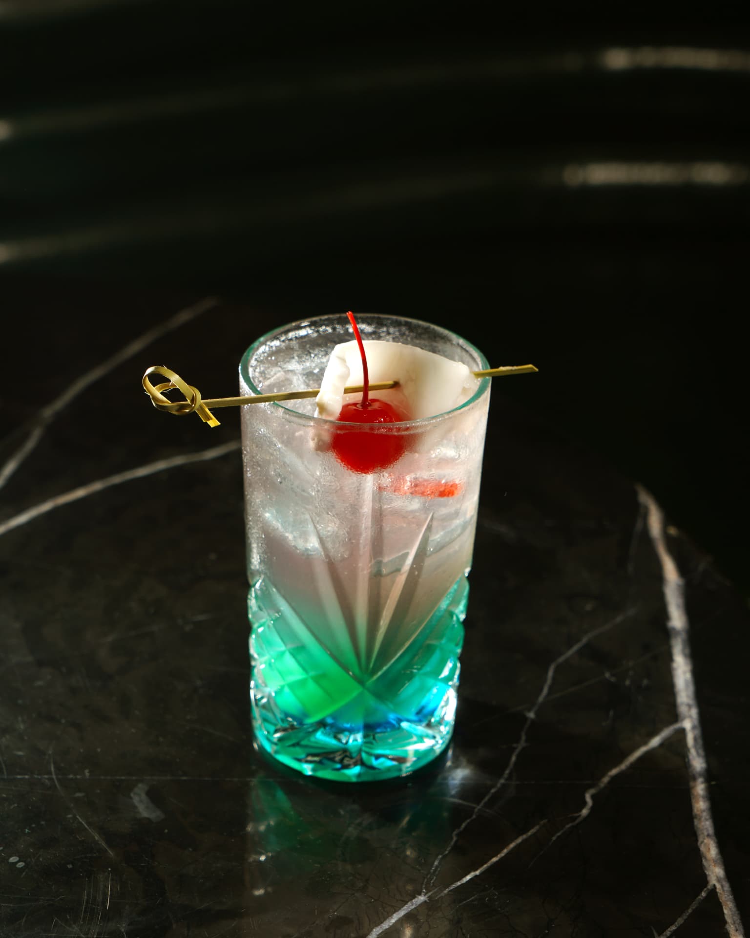 Clear highball cocktail with cherry and lychee